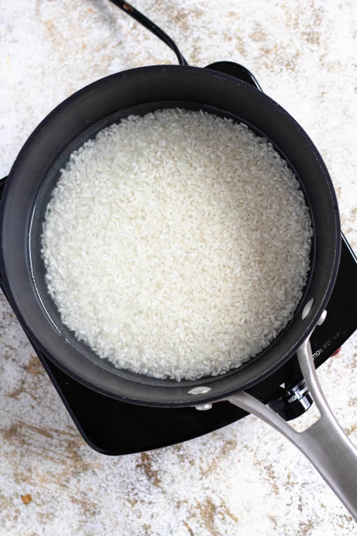 Japanese rice and water in a saucepan. 