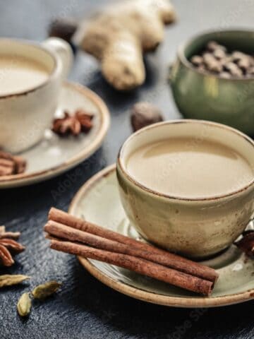 Chai Tea on serving plates with cinnamon sticks and anise seeds.