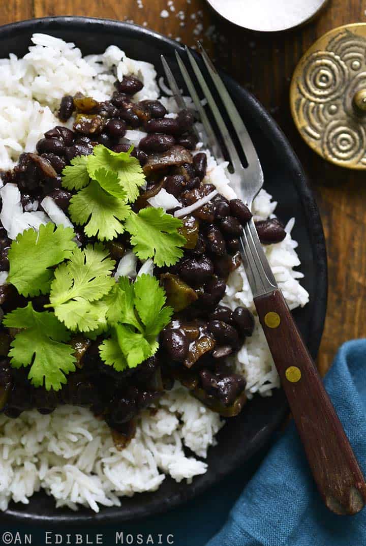 Black beans served over white rice and cilantro garnished over the top. 