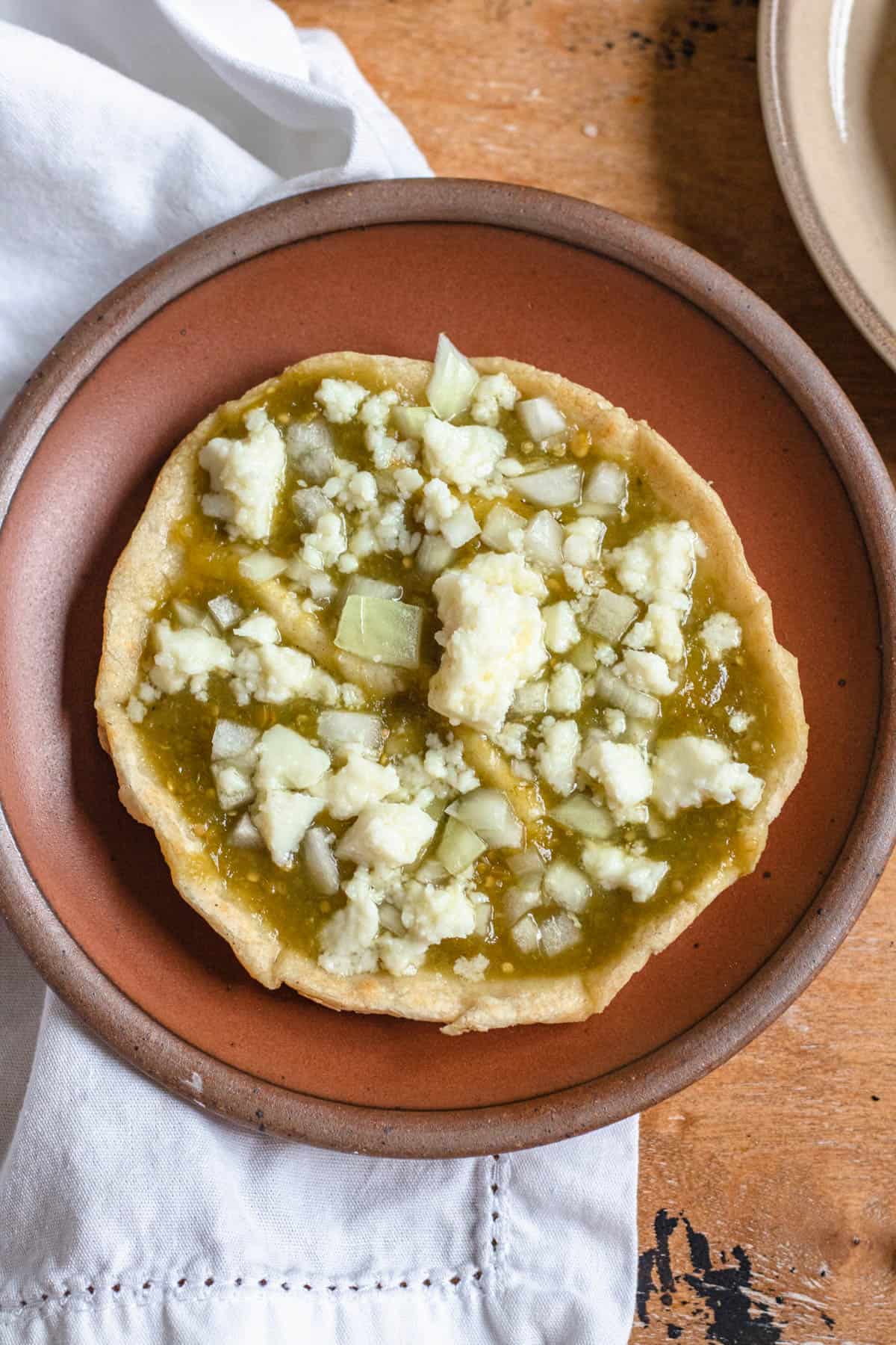 Top view of a green salsa and cheese picadita. 