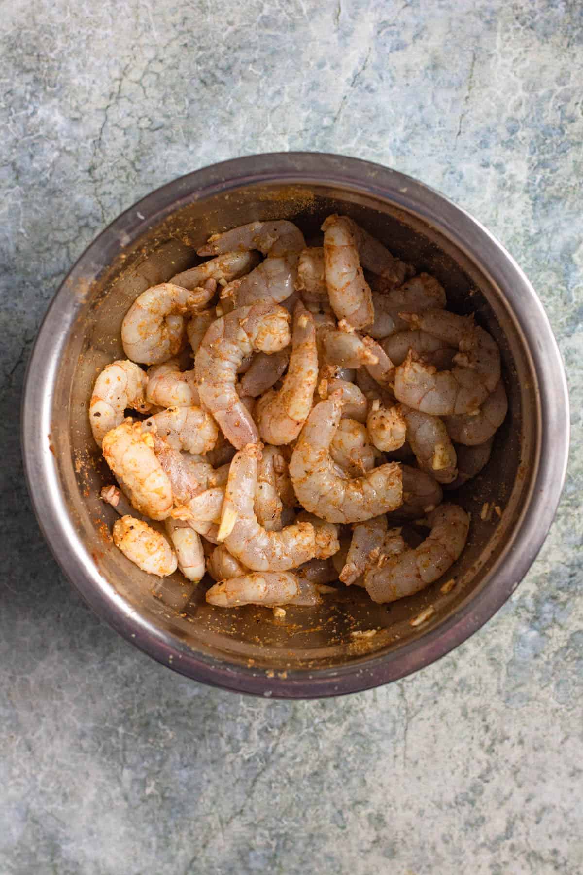 Shrimp marinating in a mixing bowl.
