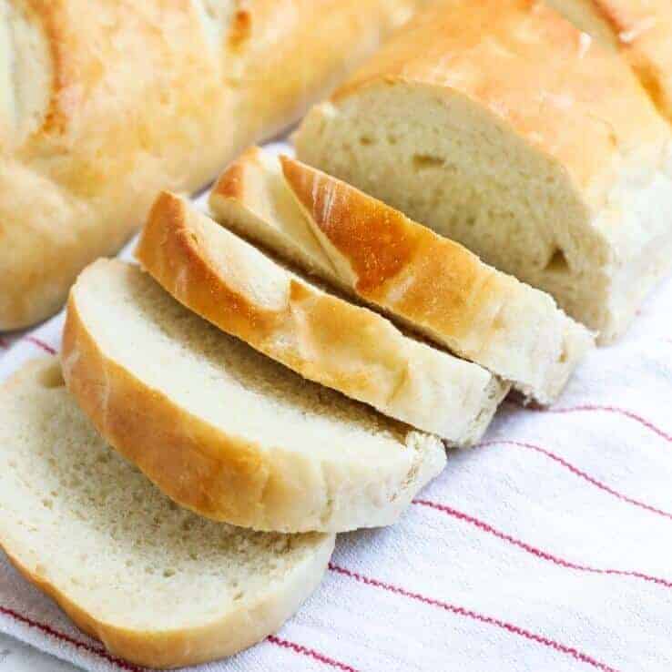 Sliced homemade french bread on a towel. 