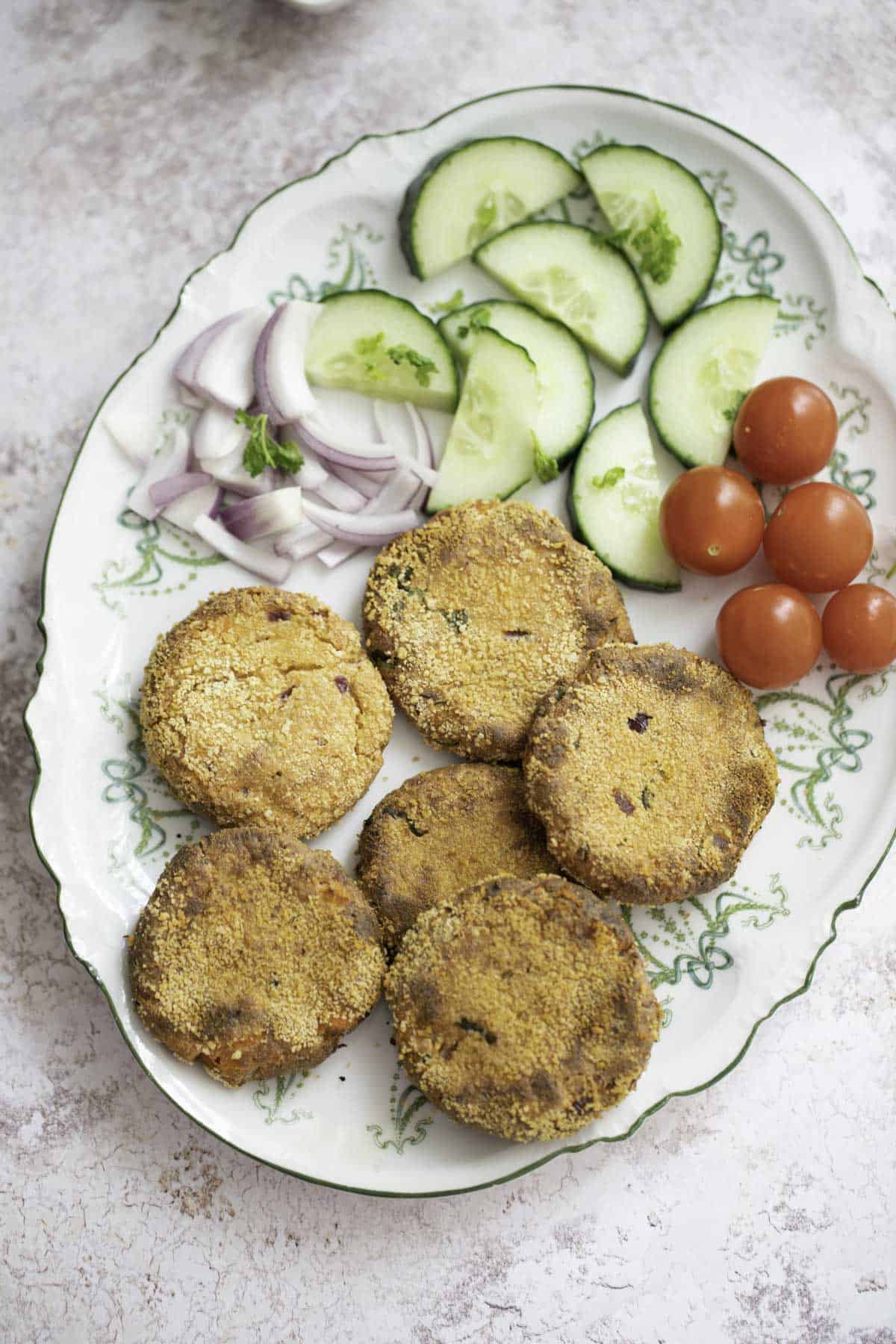 Baked paneer cutlets on a plate with cucumber 