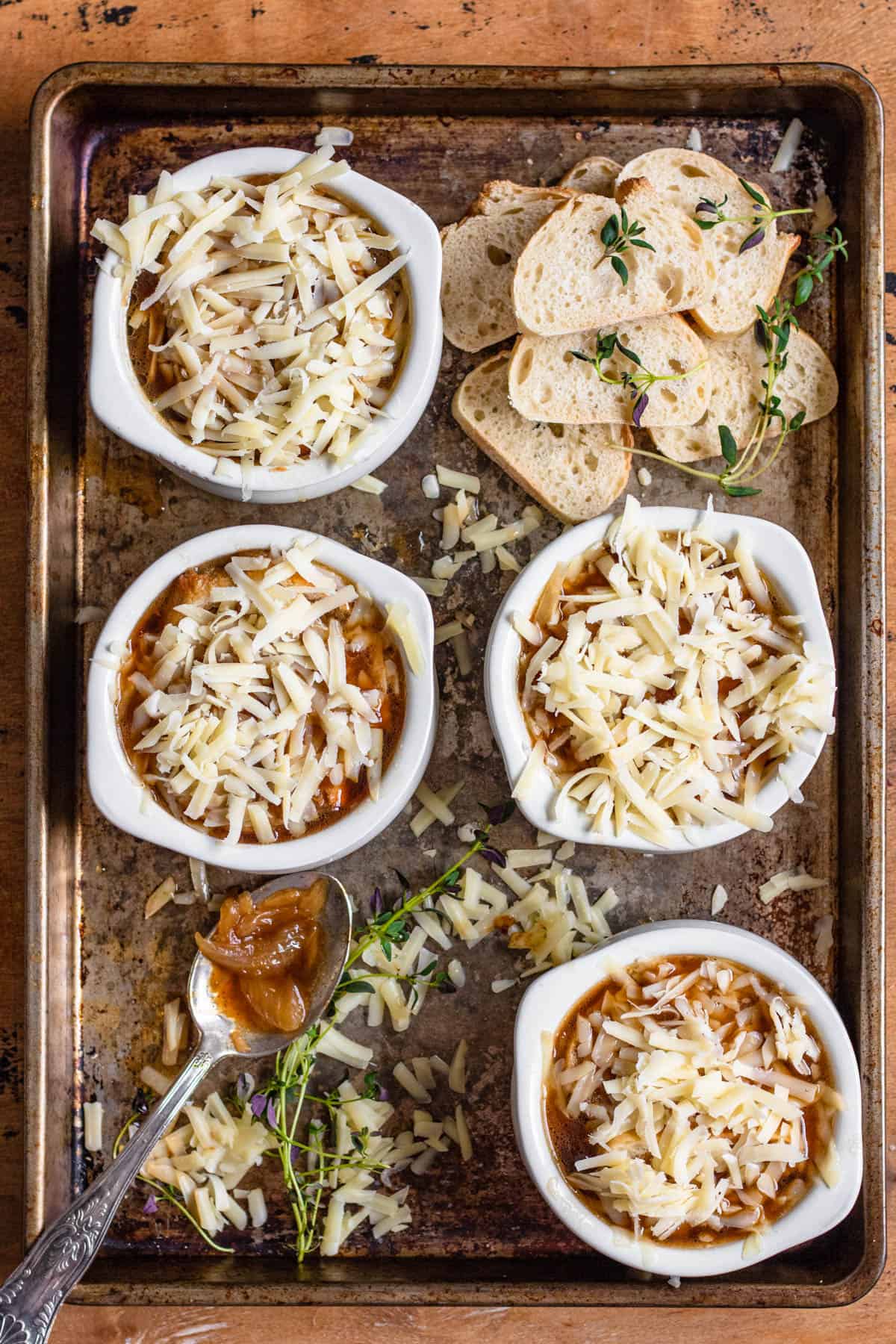 Bread and more shredded cheese tops the broth in the soup bowl for French onion soup. 