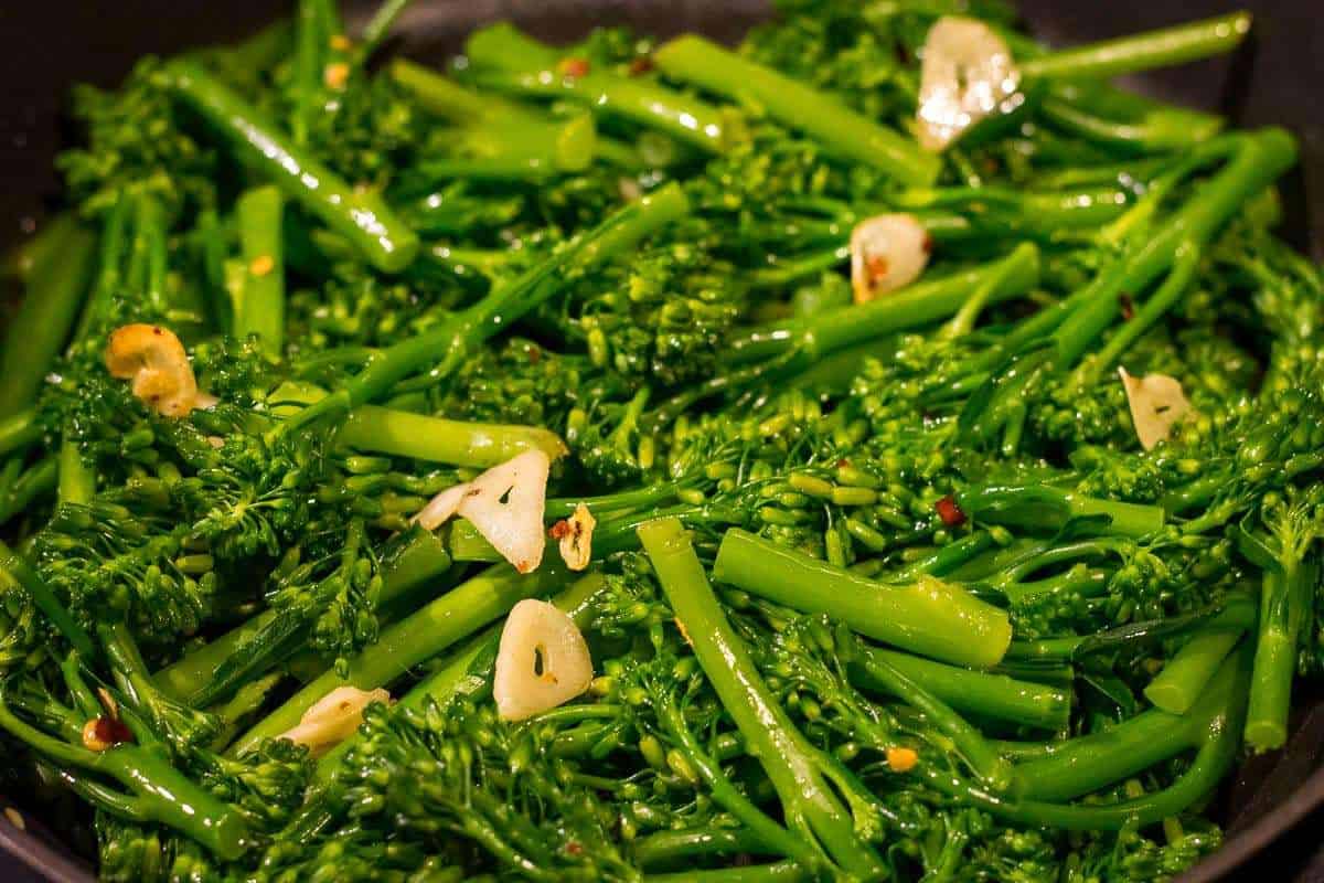 Fried tenderstem broccoli and garlic in a pan, ready to serve. 