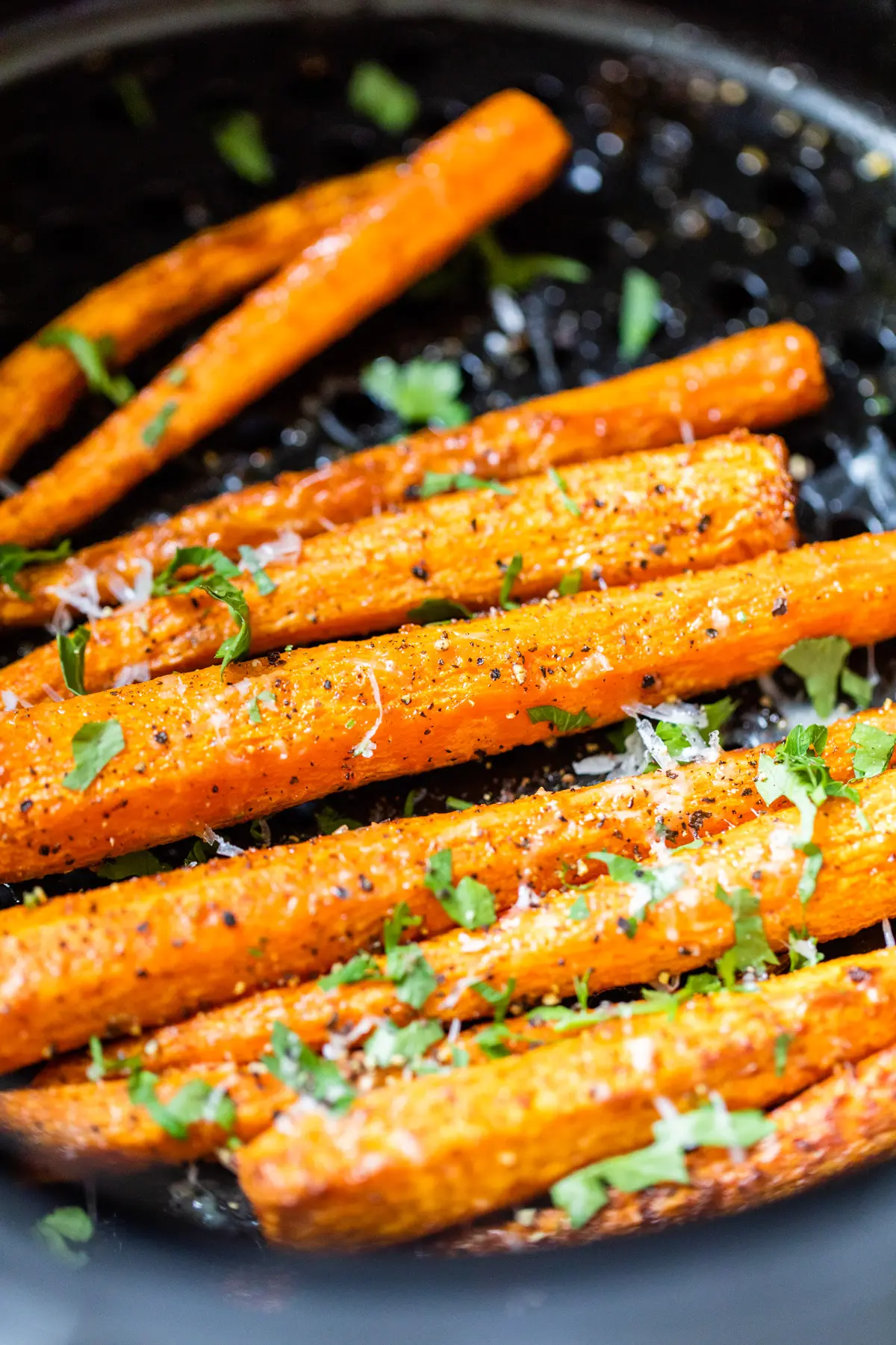 Air Fryer carrots garnished with parsley and cheese over the top. 