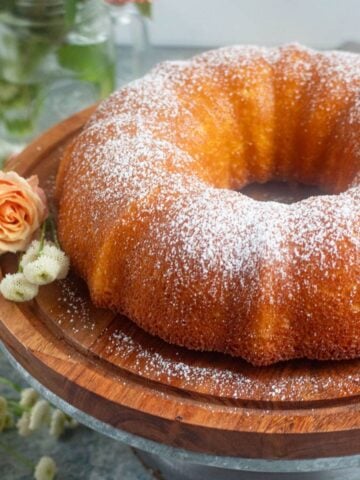 Cardamom cake on a serving platter, sprinkled with powdered sugar.