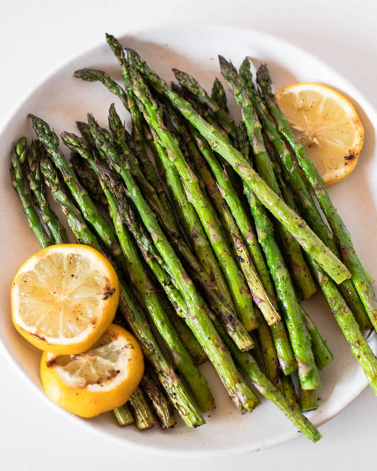 Traeger made asparagus in a platter with lemon slices. 