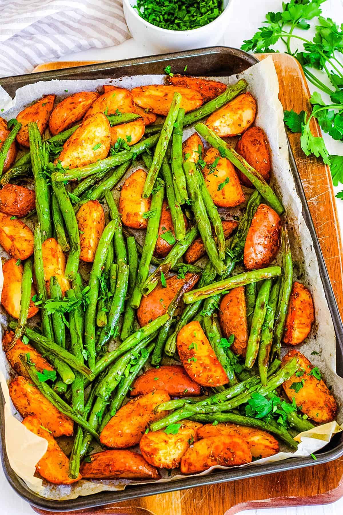 Roasted green beans and potatoes in a baking dish. 