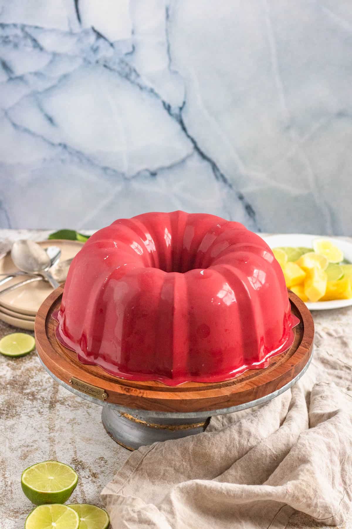 Bundt pan with lime jello salad turned upside down on a cake stand. 