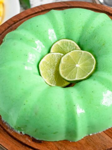 Lime Jello Salad on a large serving platter with lime slices in the center.
