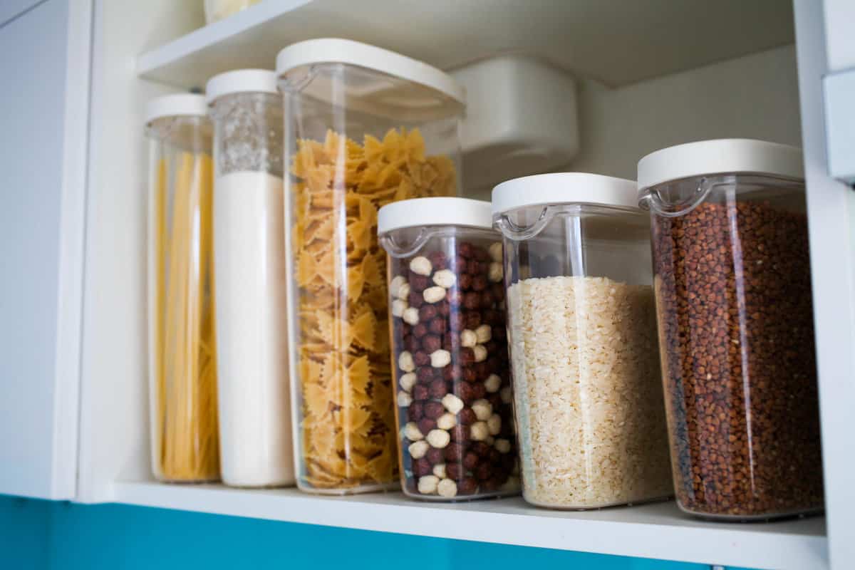 Storage containers filled with pantry staples like rice, pasta and flour. 