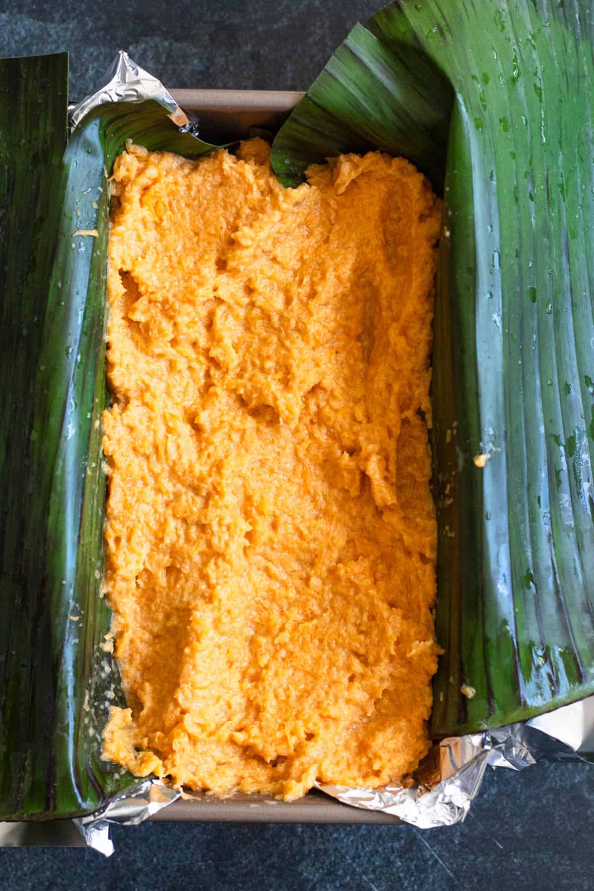 Buatoro cake batter over a banana leaf in a loaf pan. This is a dessert from Kiribati. 