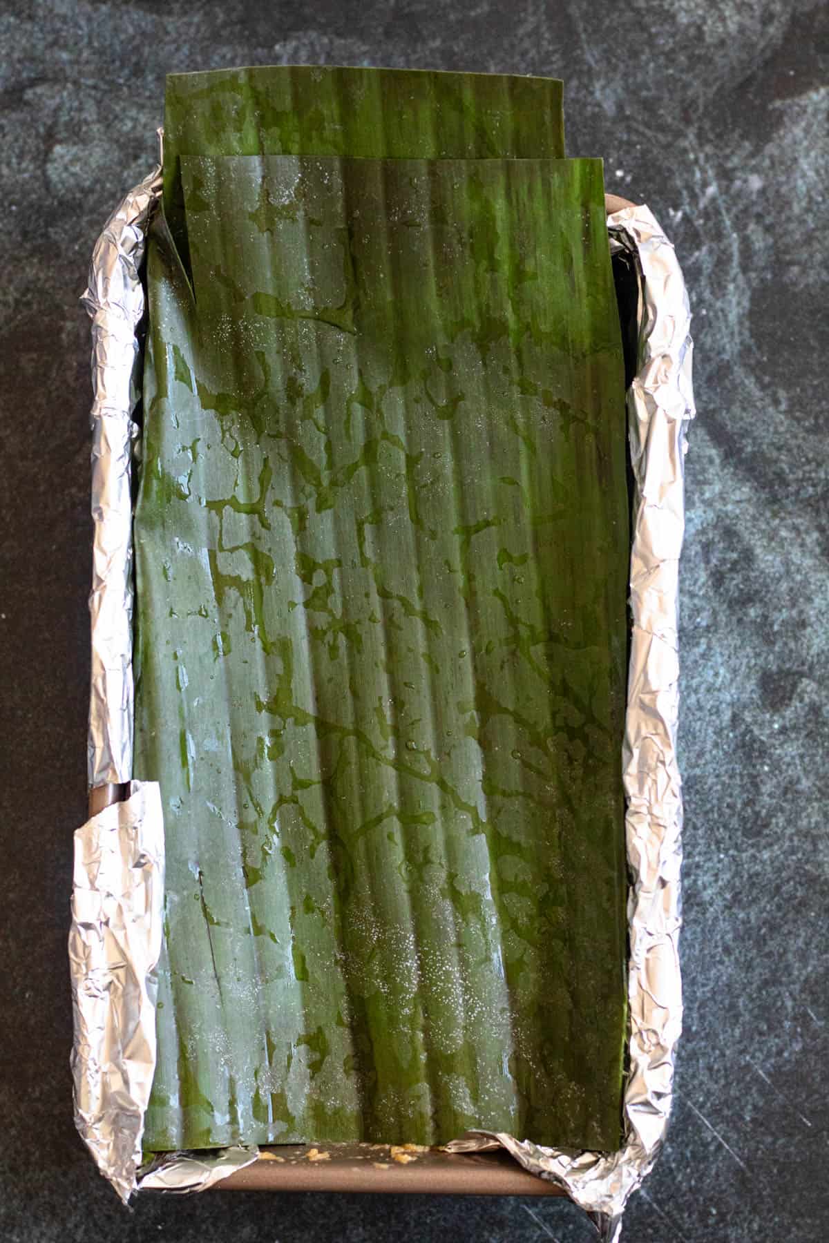 Buatoro cake batter wrapped up in a banana leaf as its about to be baked. This is a dessert prepared in Kiribati. 