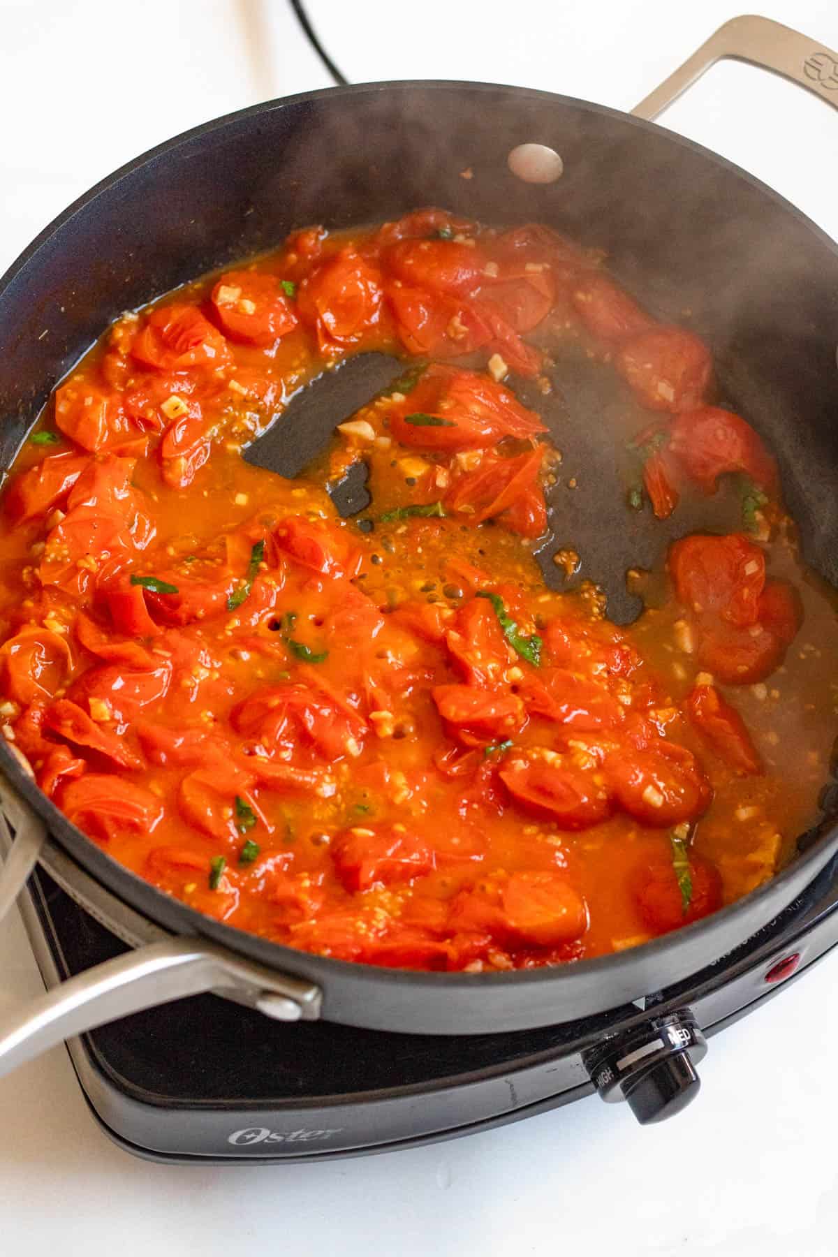Garlic tomato sauce boiling in skillet. 