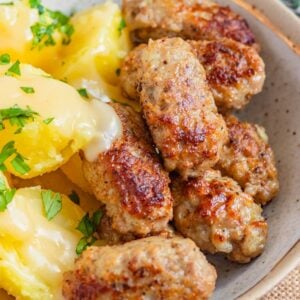 Danish meatballs, Frikadeller, served ina. bowl with potatoes and topped with a gravy.