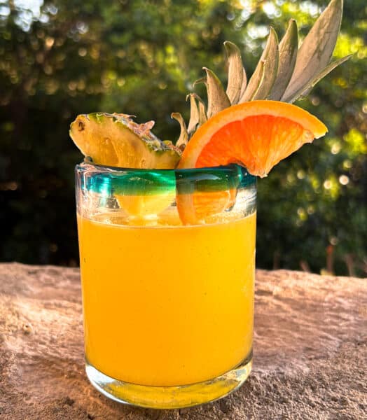 Pineapple margarita served with a pineapple and orange slice garnishes. 