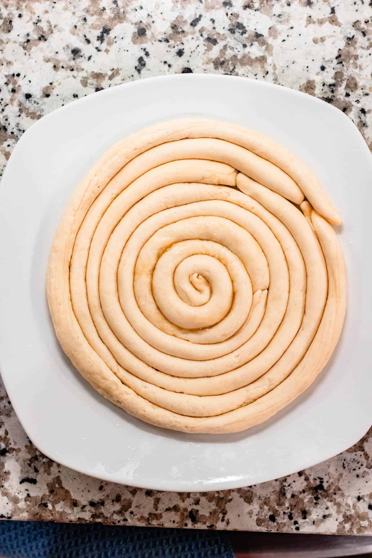 Lagman dough rolled into thin rolls and placed on a plate until finishing homemade noodles. 