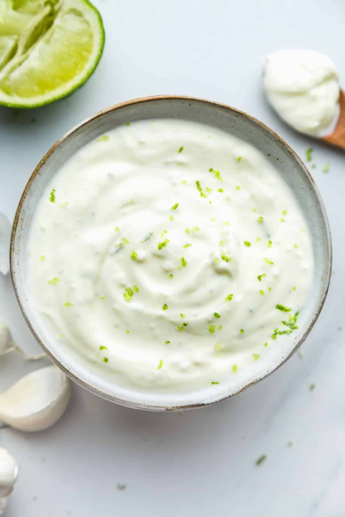 Lime crema in a bowl topped with lime zest. 