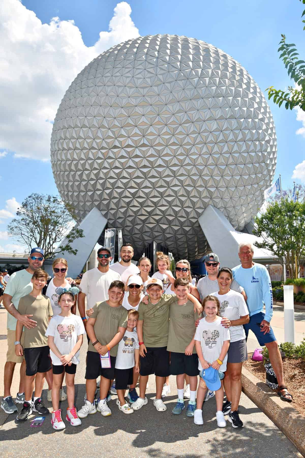 A family posing in front of the Epcot golf ball.