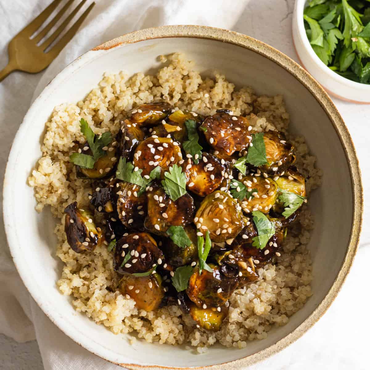 Bowl of General Tso's Brussels sprouts served over quinoa in a bowl. 
