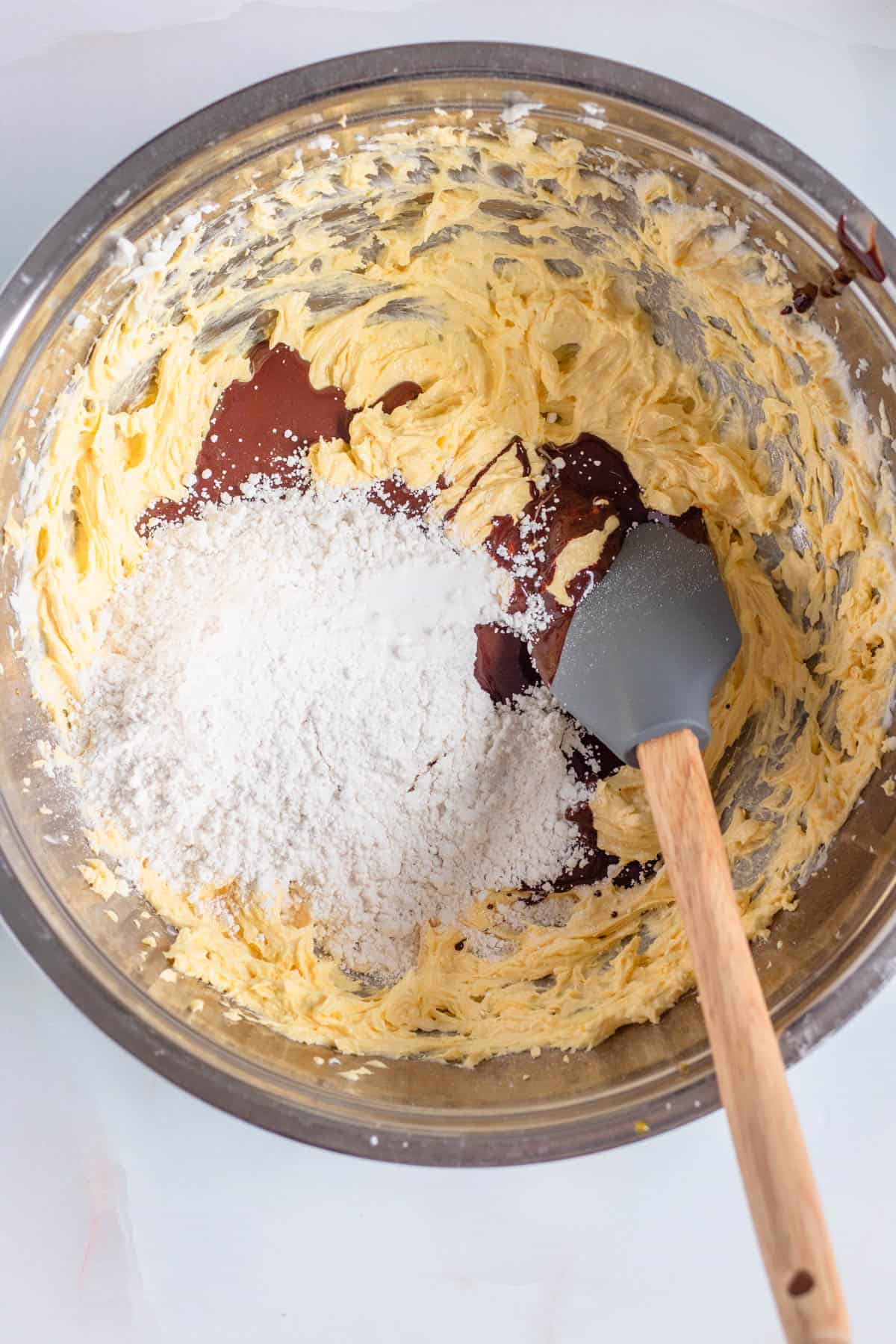 Butter and sugar creamed in the mixing bowl with flour and melted chocolate added to it. 