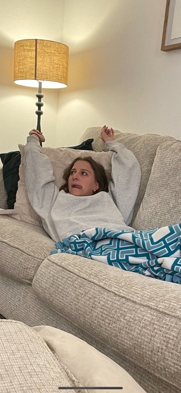 A girl making a funny face on a couch. 