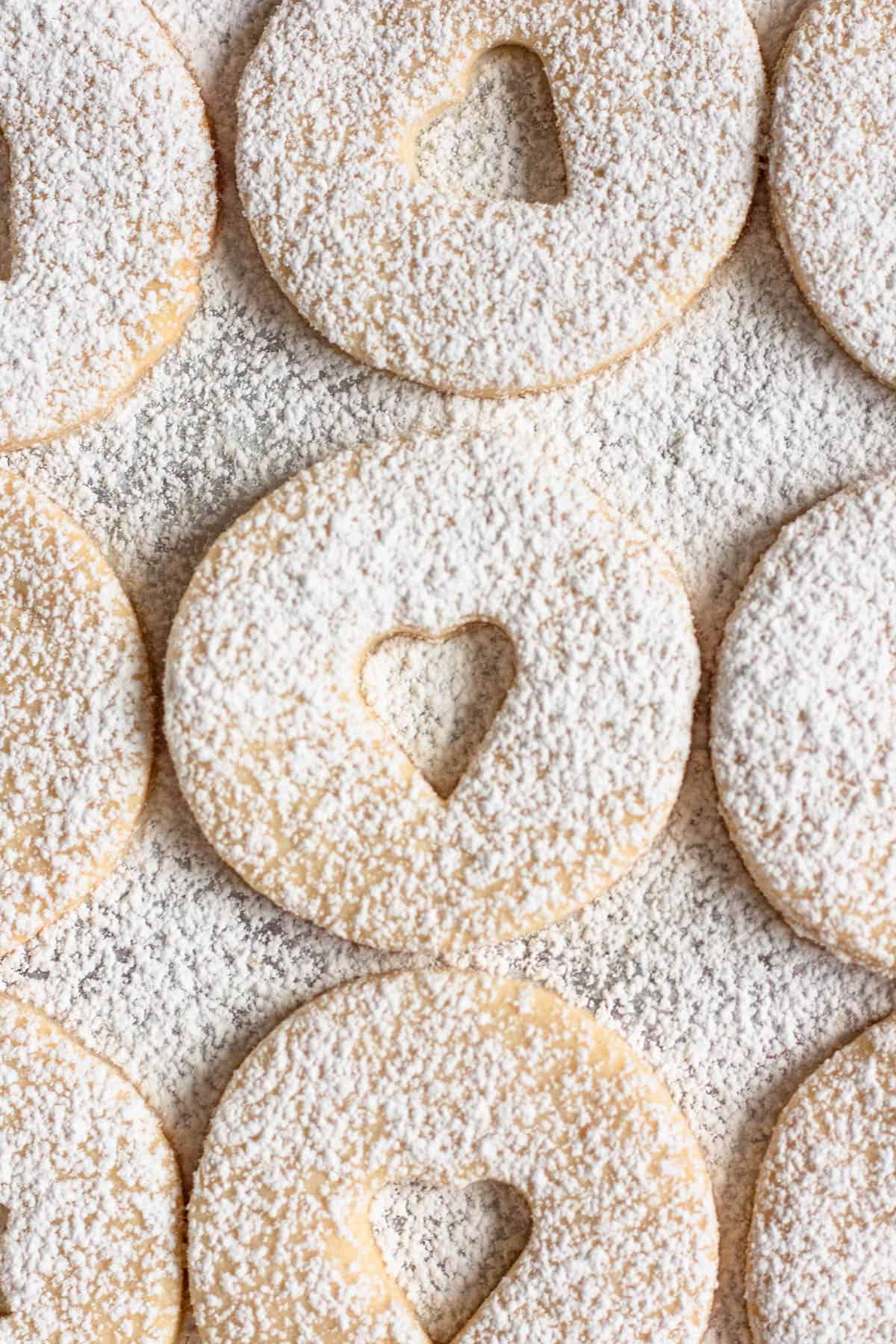 Powdered sugar sprinkled over shortbread cookies with jam. 