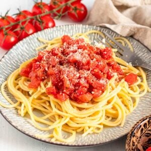 A pile of spaghetti on a plate topped with Marcella Hazan's tomato sauce.