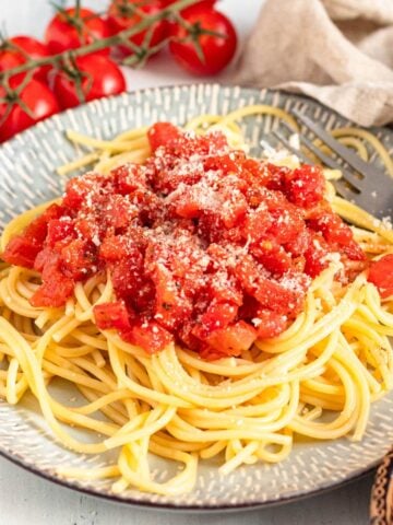 A pile of spaghetti on a plate topped with Marcella Hazan's tomato sauce.