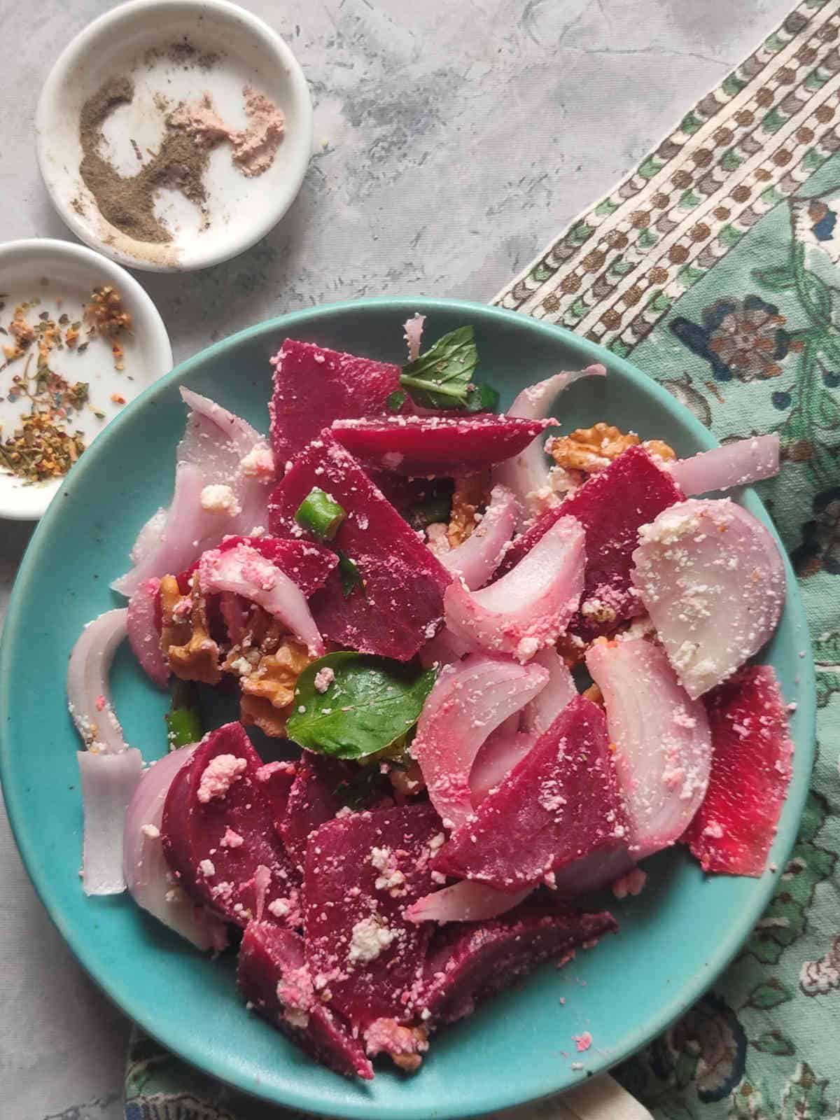 Plate filled with beet salad with feta cheese and walnuts. 
