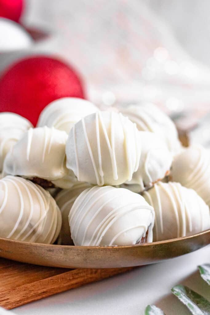White chocolate gingerbread truffles stacked up on a plate, ready to serve. 