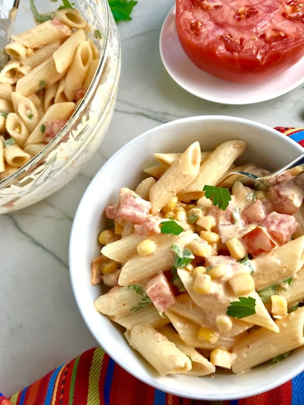 Bowl of Mexican corn pasta salad with tomatoes ready to enjoy. 
