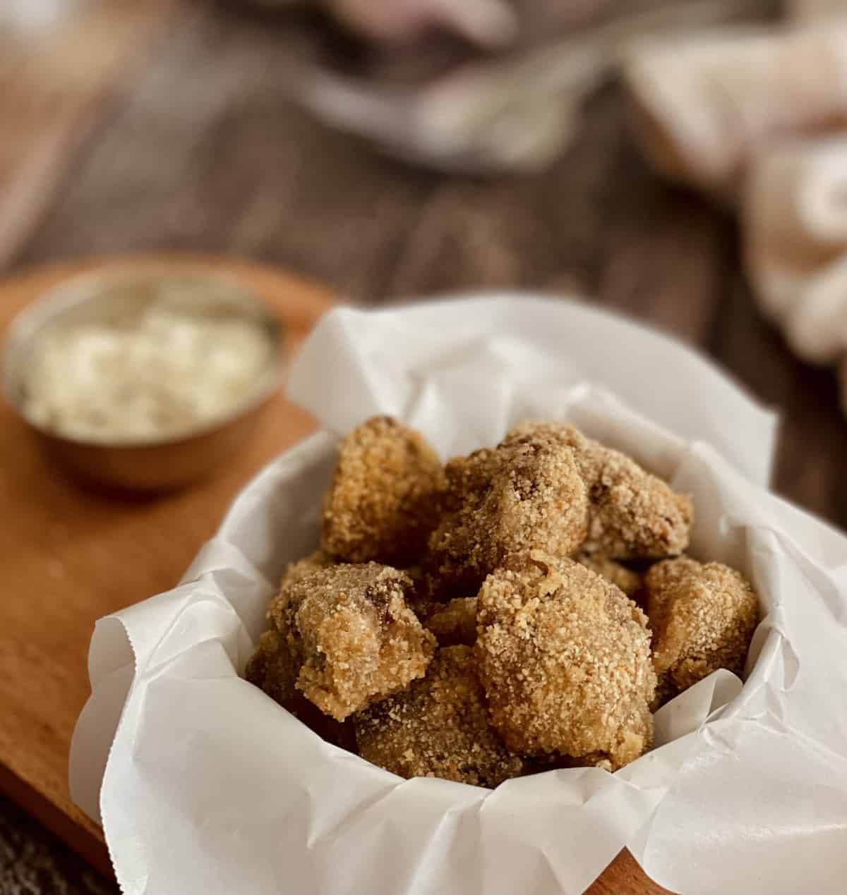 No egg garlic breaded mushrooms in a parchment paper covered bowl. 