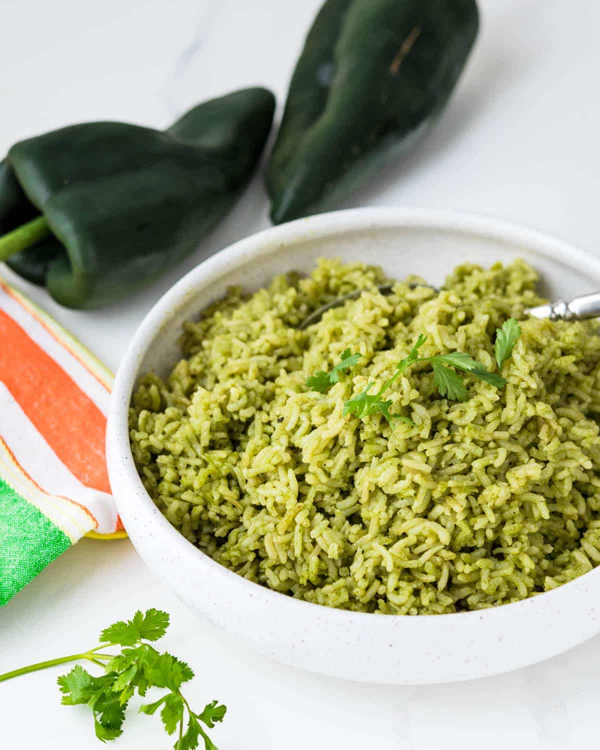 Spoon resting in a bowl of green rice or arroz verde. 