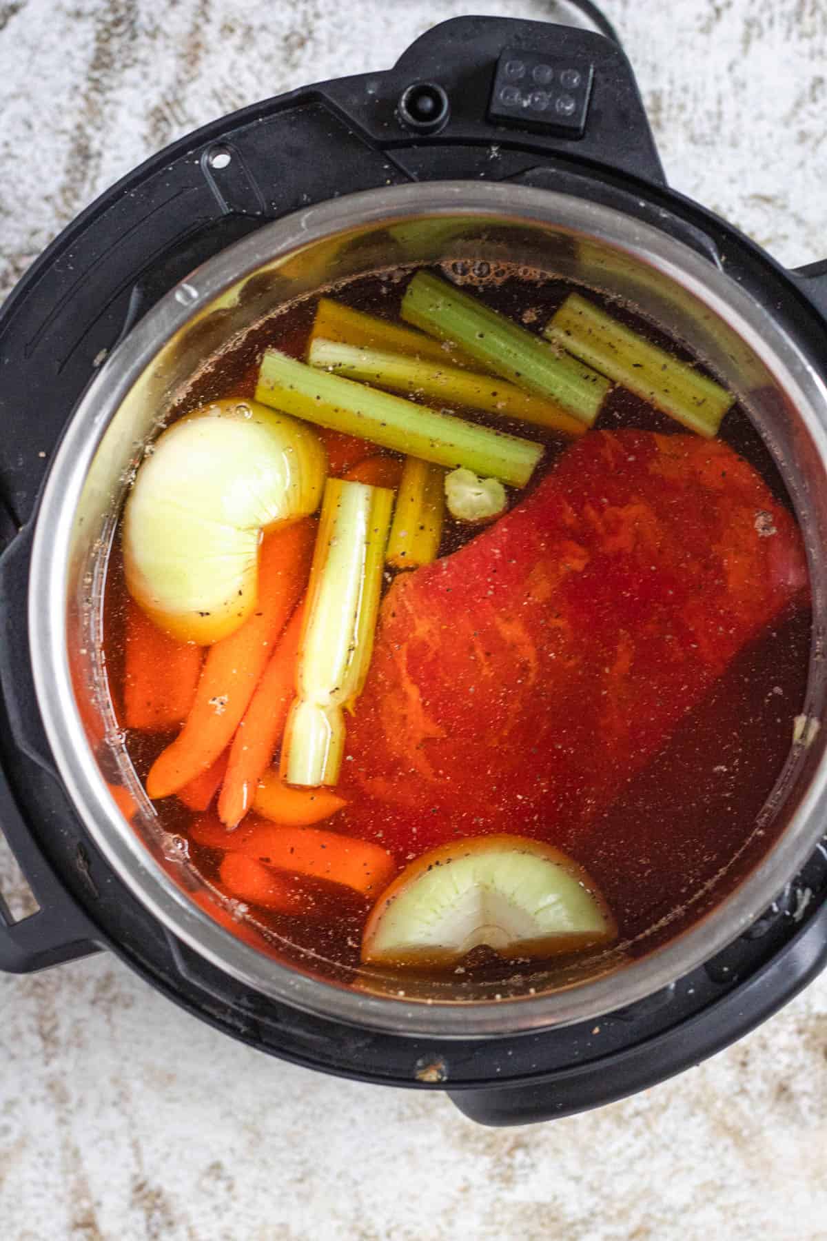 Broth added to the instant pot with the beef and vegetables. 