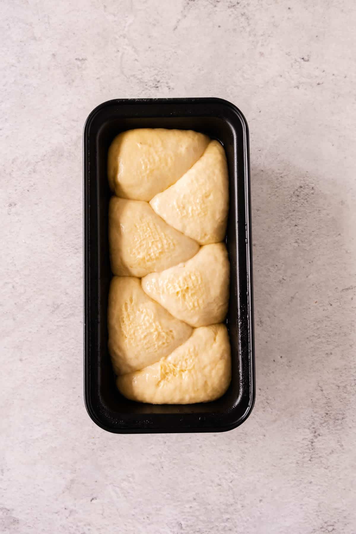 Brioche bread dough risen in the loaf pan. 