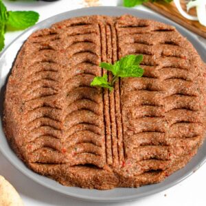 Kibbeh Nayeh on a large platter topped with mint.