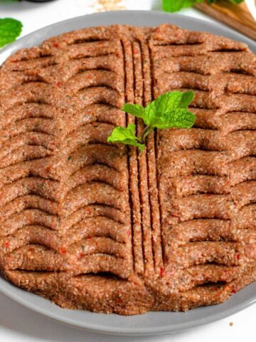 Kibbeh Nayeh on a large platter topped with mint.