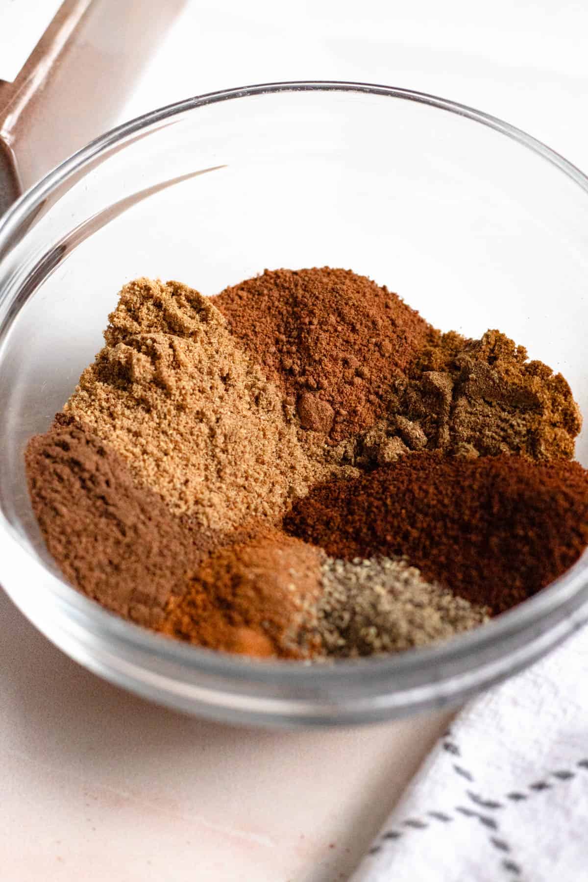 Ingredients for preparing Lebanese 7 Spice measured out and added to a glass measuring bowl. 