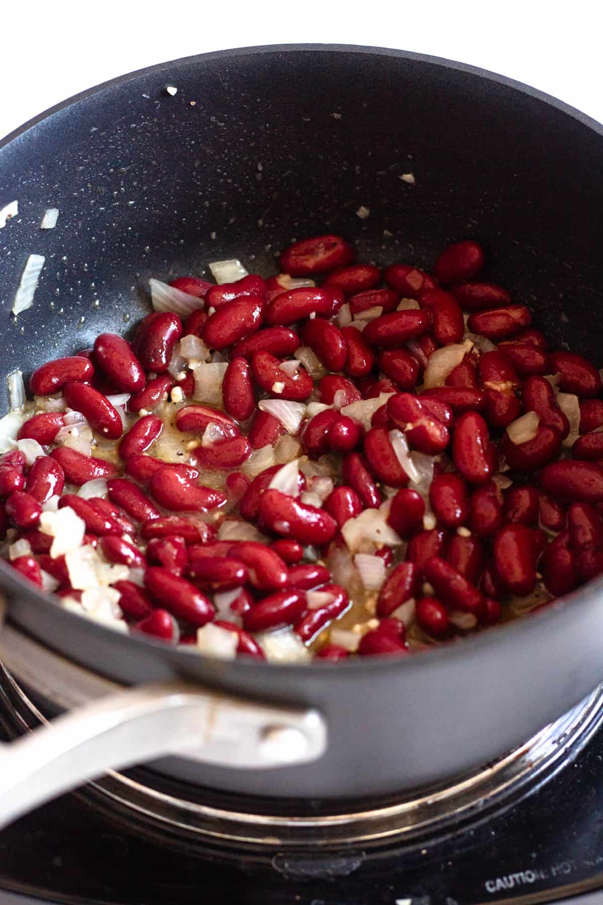 Red kidney beans and seasonings added to the onion mixture. 