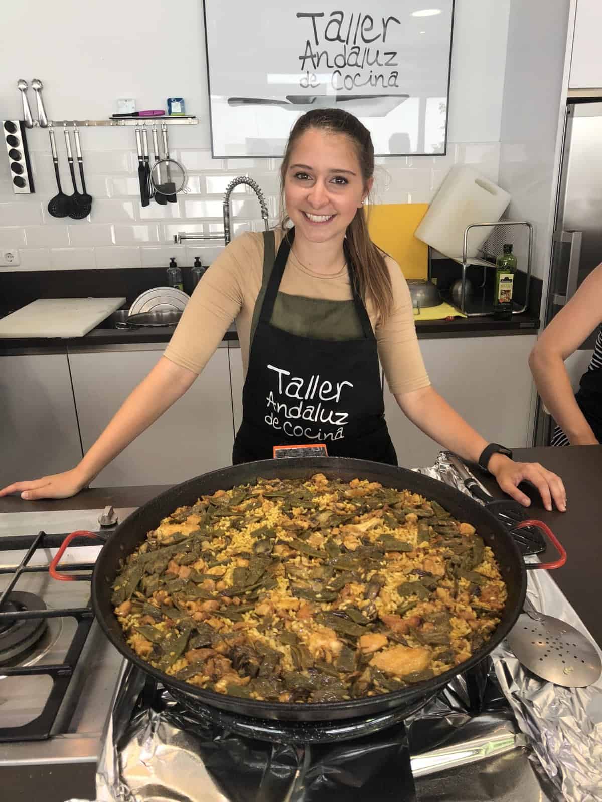 Alexandria standing in front of a large pan of paella in Spain.