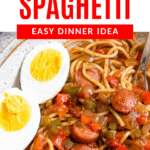 Pinterest image of a plate of Haitian Spaghetti with a boiled egg, halved, garnished on the side.
