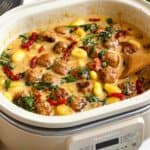 A Magnifique slow cooker with a batch of Slow Cooker Tuscan Chicken Meatballs with Gnocchi ready to enjoy.