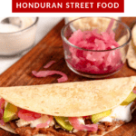 Pinterest image of Honduran Baleadas on a cutting board with ingredients to prepare more behind it.