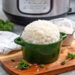 Large green serving bowl filled with long grain white rice prepared in the instant pot.