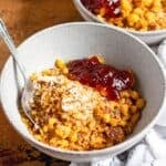 A bowl of crispy Ribel topped with granulated sugar and fruit jam, ready to be served.