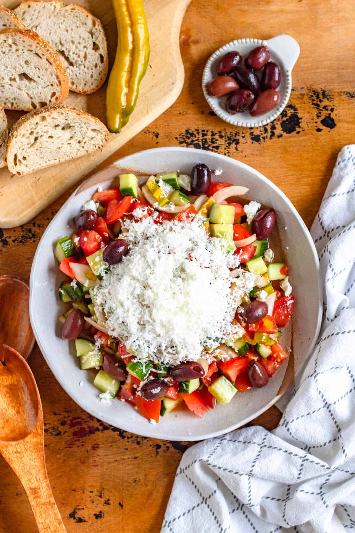 A Refreshing shopska salad topped with olives and feta cheese ready to serve.