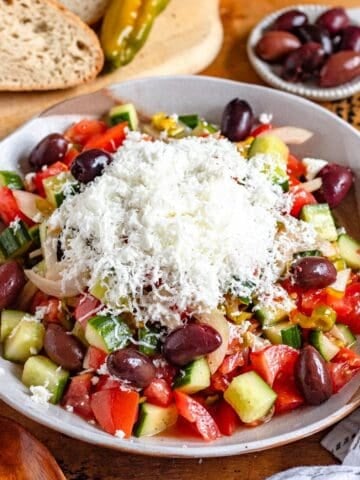 A bowl of refreshing Shopska Salad topped with feta cheese.