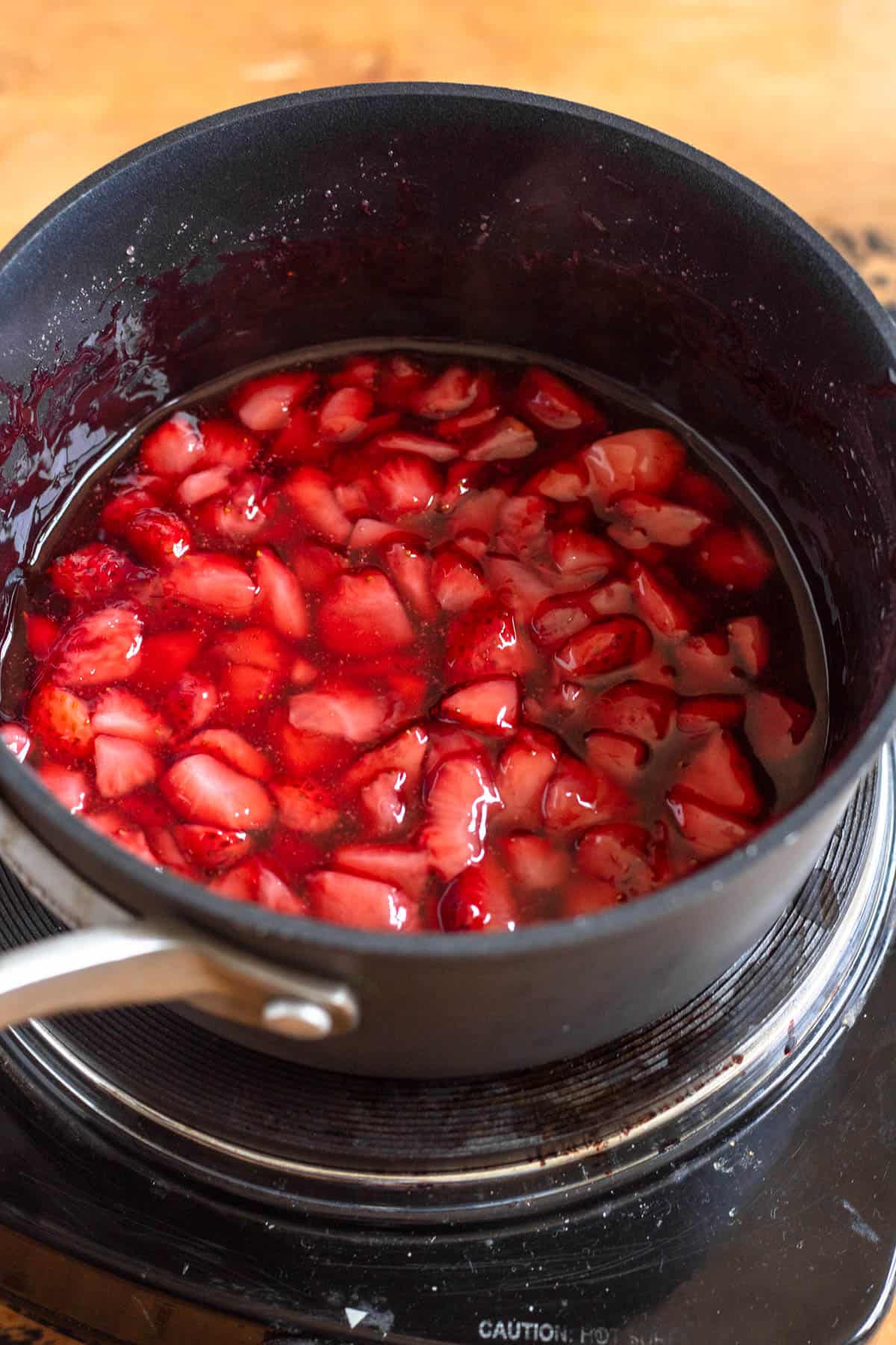 Strawberries and granulated sugar were added to a saucepan and gently heated.